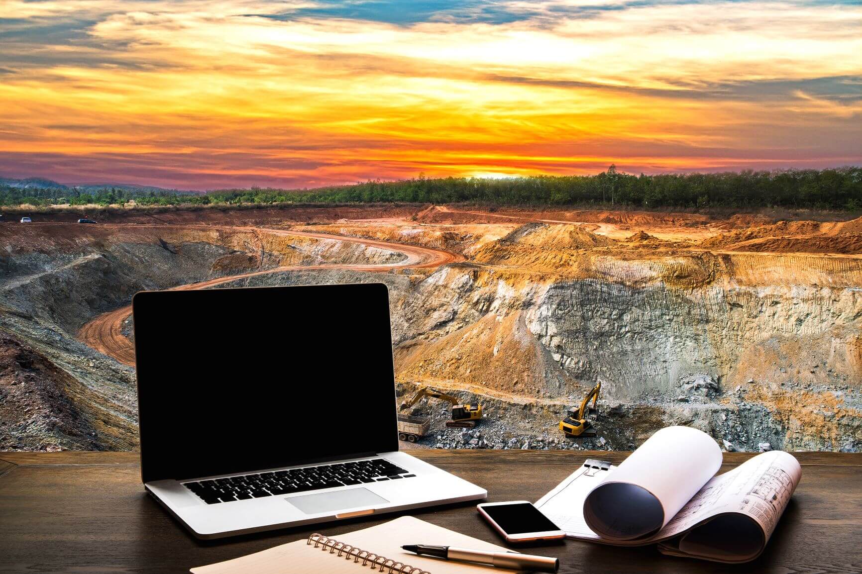 A laptop with a mine quarry in the background